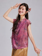 Model wearing a sleeveless mulberry-rose silk top with a Mandarin collar and floral print.