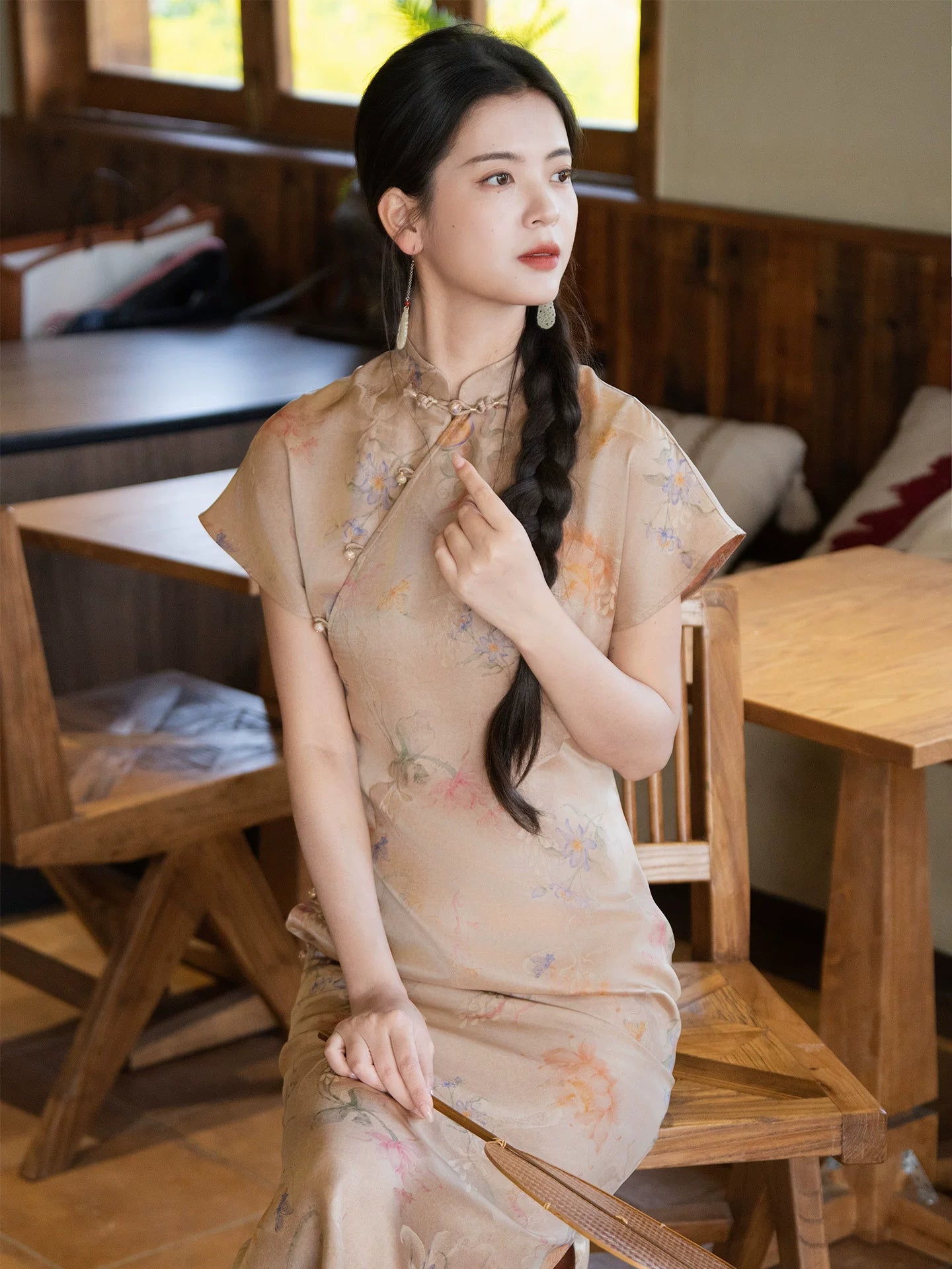 Woman wearing a mulberry silk floral cheongsam dress indoors