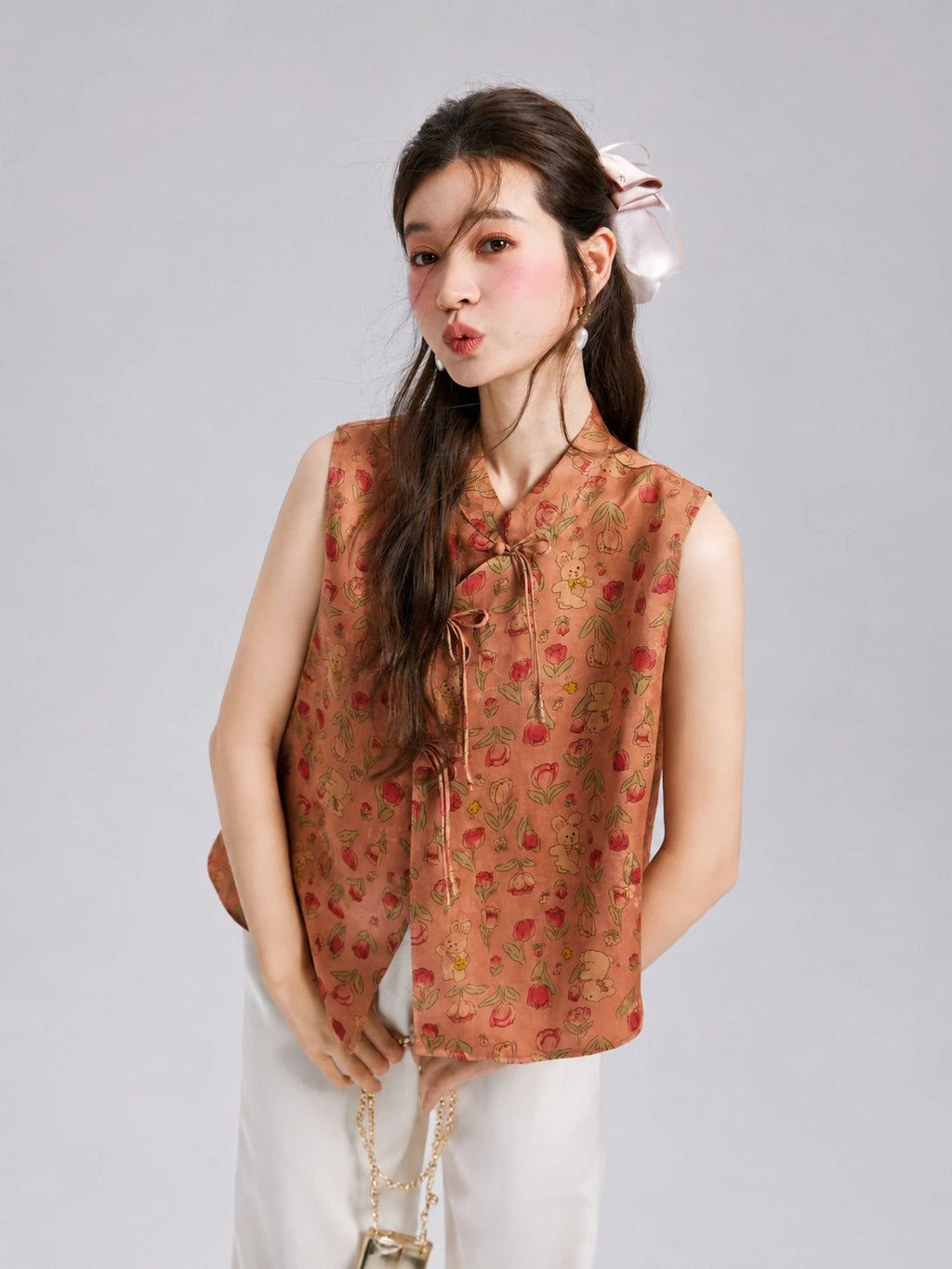 Front view of a sleeveless Gambiered Silk jacquard vest featuring flowers, rabbits and decorative knot closures