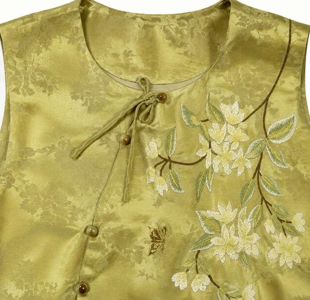 Product close-up showing the round neckline and embroidered floral branch on the olive jacquard vest