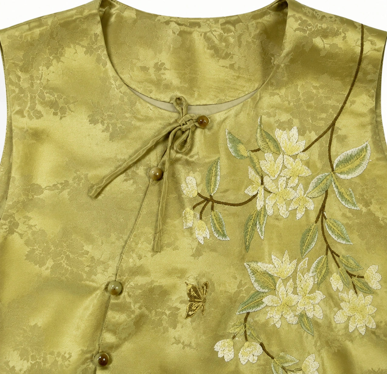 Product close-up showing the round neckline and embroidered floral branch on the olive jacquard vest