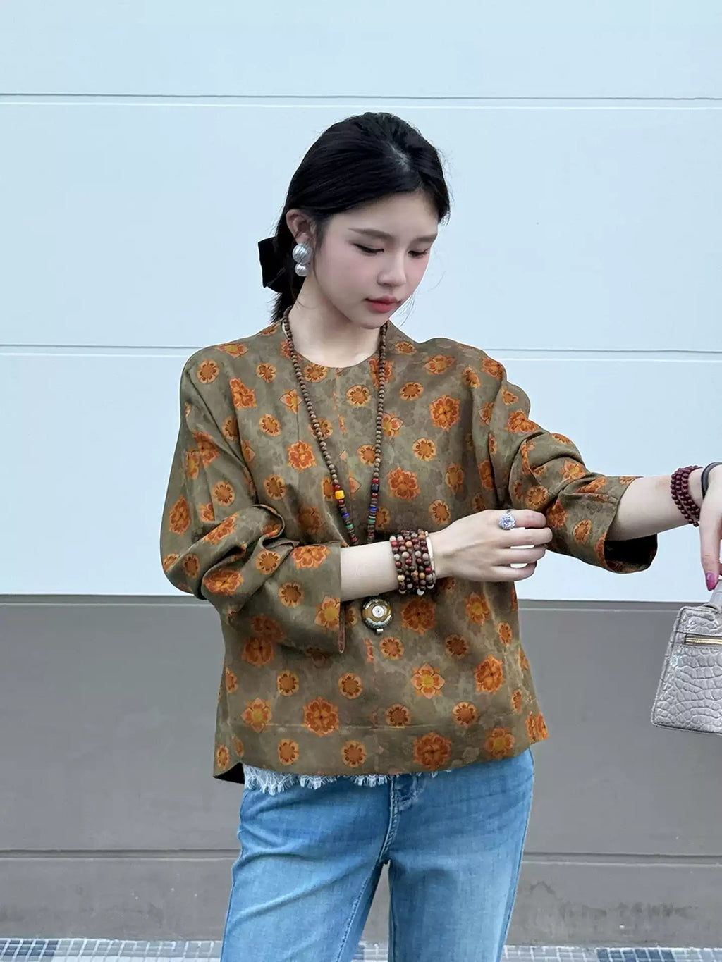 Model wearing an olive floral mulberry silk top with long straight sleeves