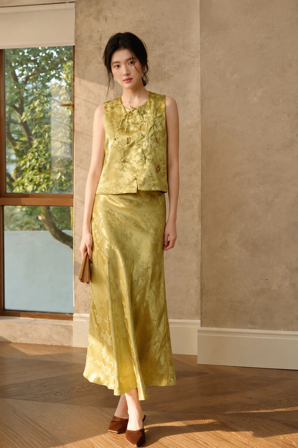 Model wearing the olive embroidered jacquard vest styled with a matching long skirt