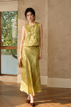 Model wearing the olive embroidered jacquard vest styled with a matching long skirt
