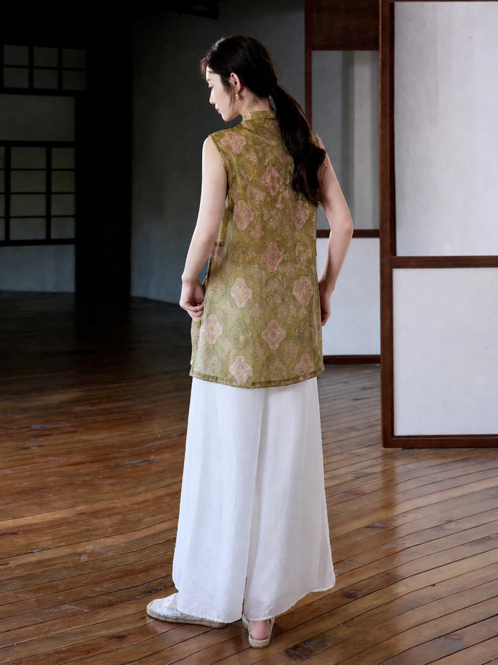 Back view of olive-green sleeveless jacquard long vest with blush medallion print