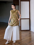 Front view of Gambiered Silk olive medallion jacquard long vest styled with white wide-leg trousers