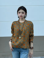 Front view of a model wearing a relaxed olive patterned silk pullover top