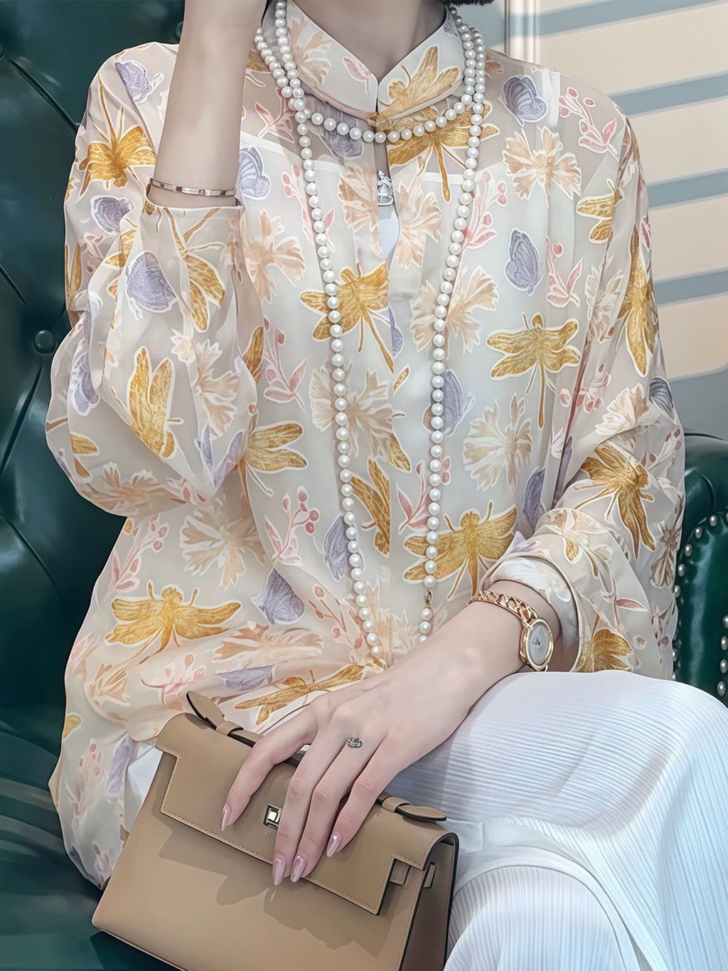 Detail view of a pastel floral silk-blend blouse styled with a pearl necklace and handbag