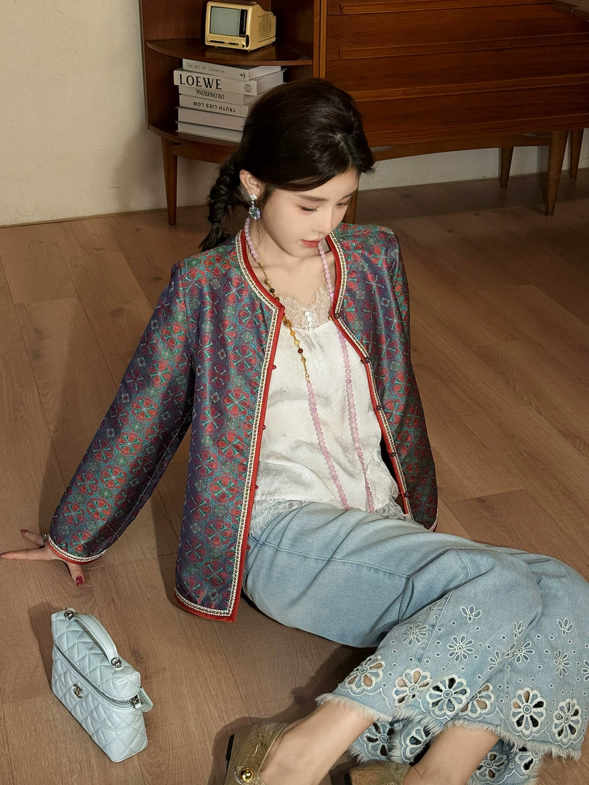 Model wearing a teal patterned mulberry silk jacket styled with a white top and light blue jeans