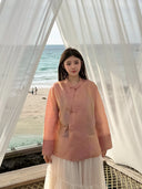 Model wearing a lightweight peach pink mulberry silk top with long straight sleeves