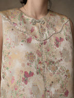 Close-up of the floral jacquard, pearl-like trim, contrast piping and decorative frog buttons