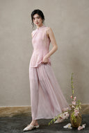 Model wearing a blush-pink silk-rich cut-velvet Mandarin vest with flowing pink trousers