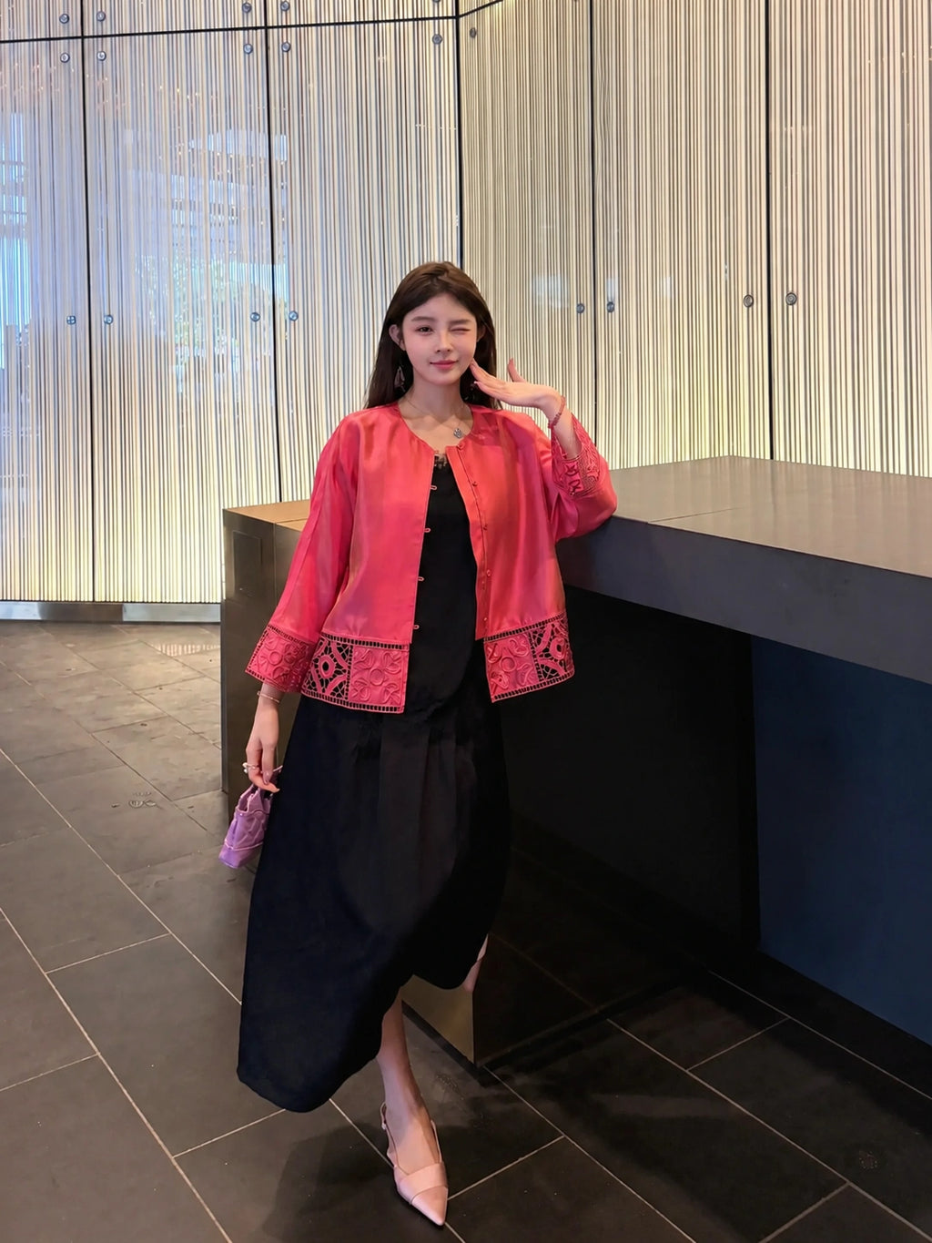 Front view of a pink Chinese-inspired silk jacket with decorative openwork detailing