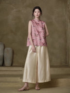 Model wearing the Gambiered Silk dusty pink horse-motif jacquard vest with ivory wide-leg trousers