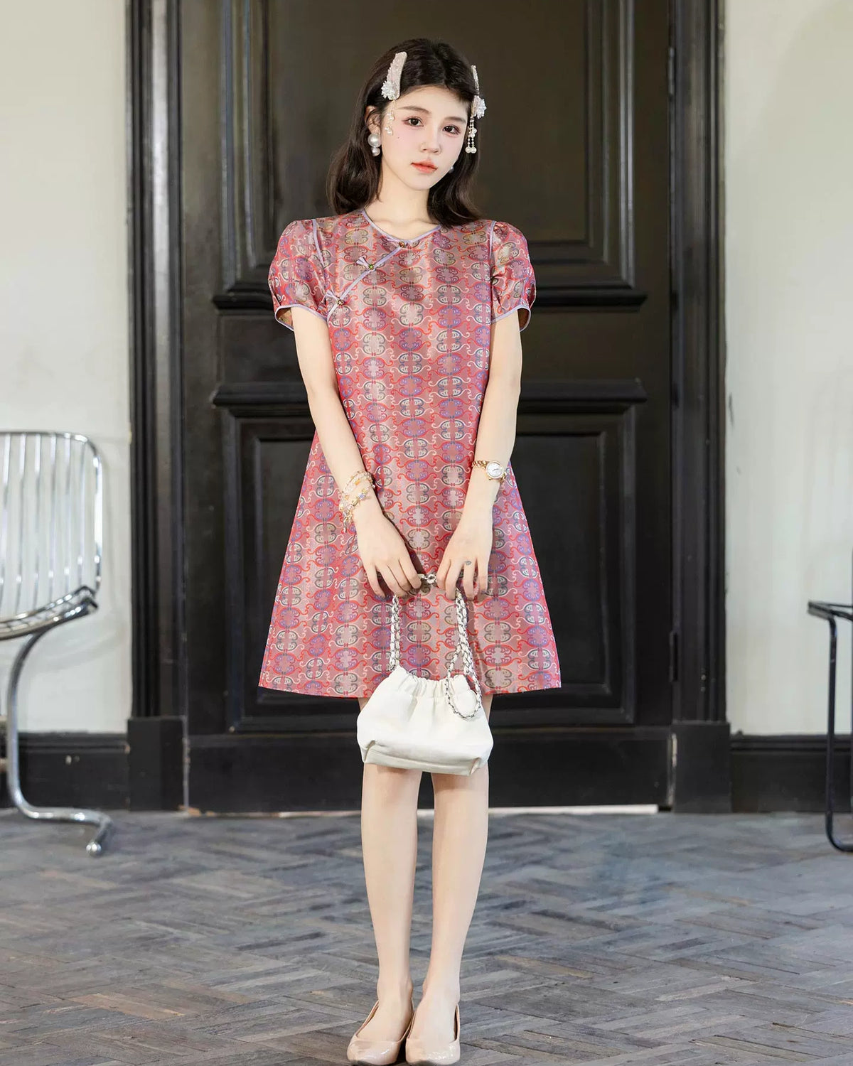 Full-length view of a pink patterned 100% mulberry silk dress with short puff sleeves and Chinese knot details.