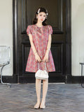 Full-length view of a pink patterned 100% mulberry silk dress with short puff sleeves and Chinese knot details.