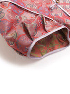 Close-up of the pink mulberry silk fabric showing the traditional-inspired pattern, piping, and Chinese knot detail.