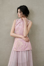 Portrait of a model wearing a blush-pink Mandarin-collar vest with lustrous champagne floral patterns