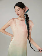 Woman wearing the Gambiered Silk Peach Mist gradient mandarin collar maxi dress in a close-up portrait.