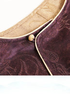 Close-up of a plum Chinese-inspired silk-blend top showing the diagonal front closure and gold piping
