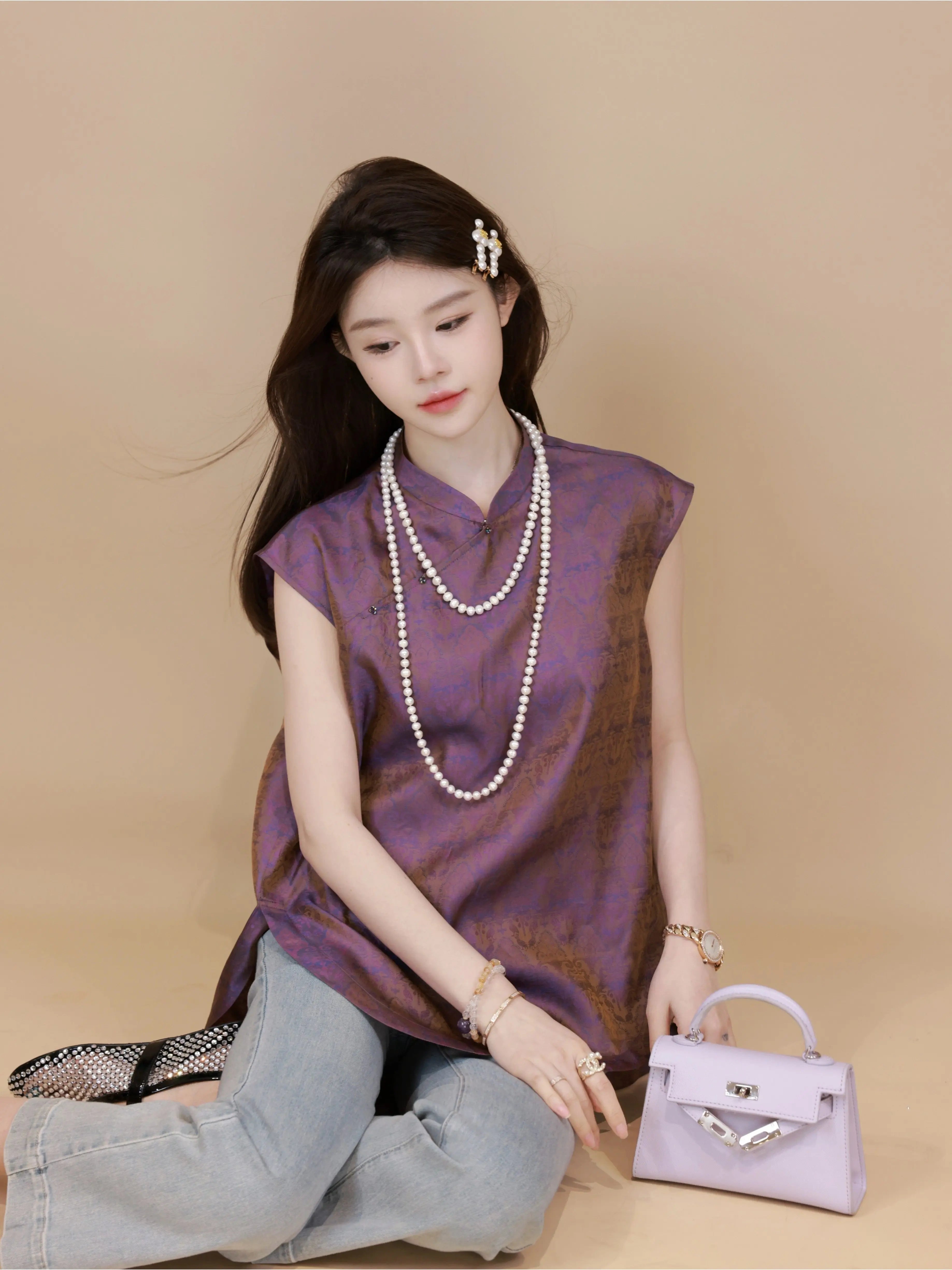 Model wearing a plum purple mulberry silk sleeveless top while seated