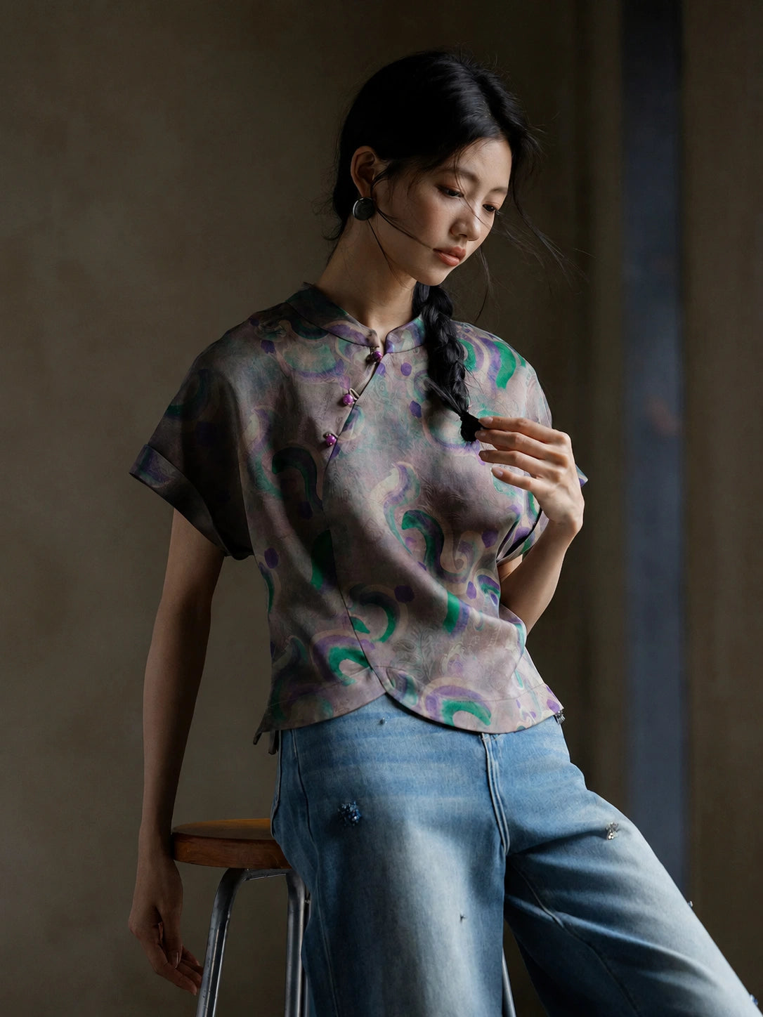 Woman wearing a 100% mulberry silk Gambiered Silk printed blouse with a mandarin collar and handmade frog buttons.