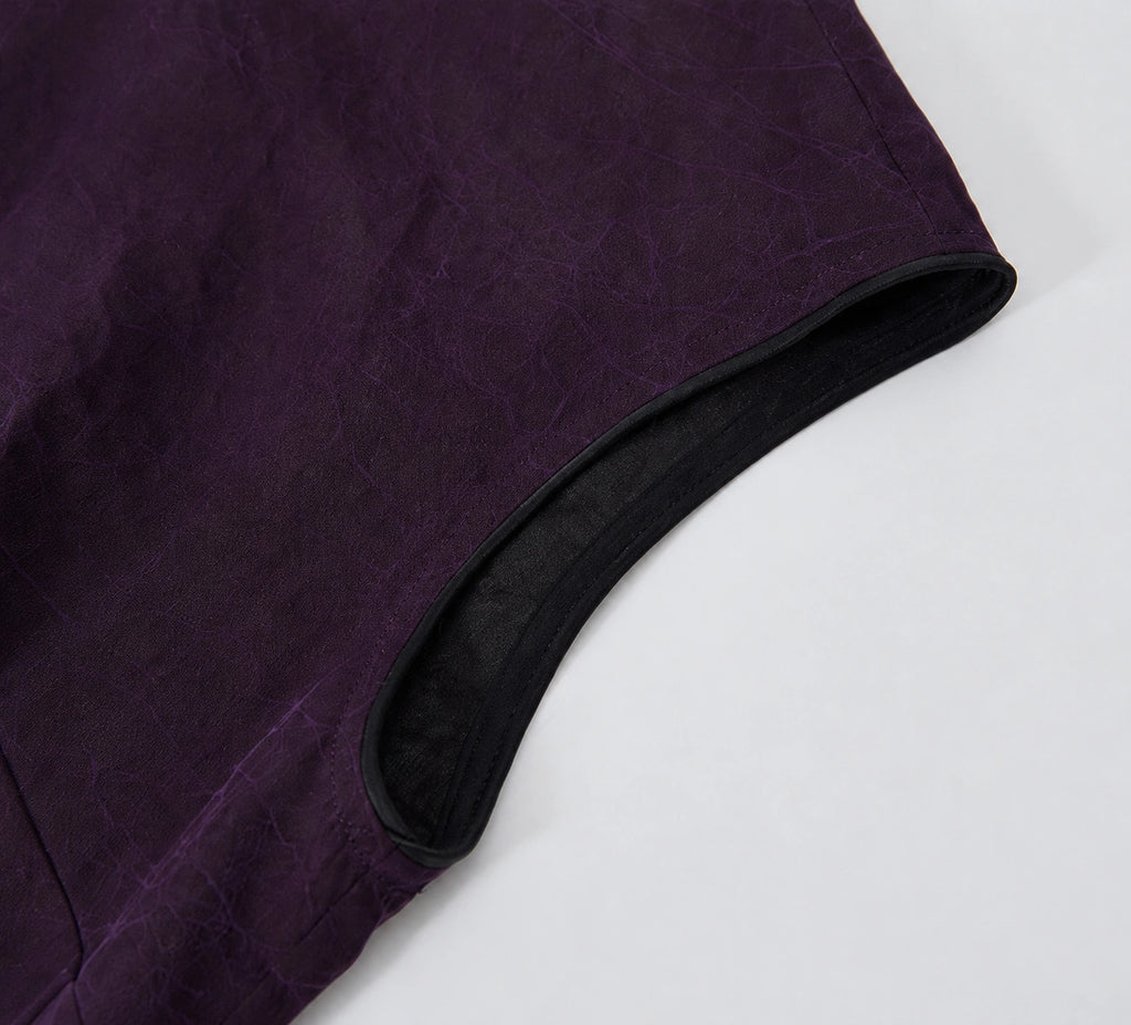 Close-up of purple crackle-textured gambiered silk fabric with contrasting black piping.