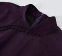 Close-up of the Mandarin collar, black piping and bead embellishment on a purple silk qipao dress.