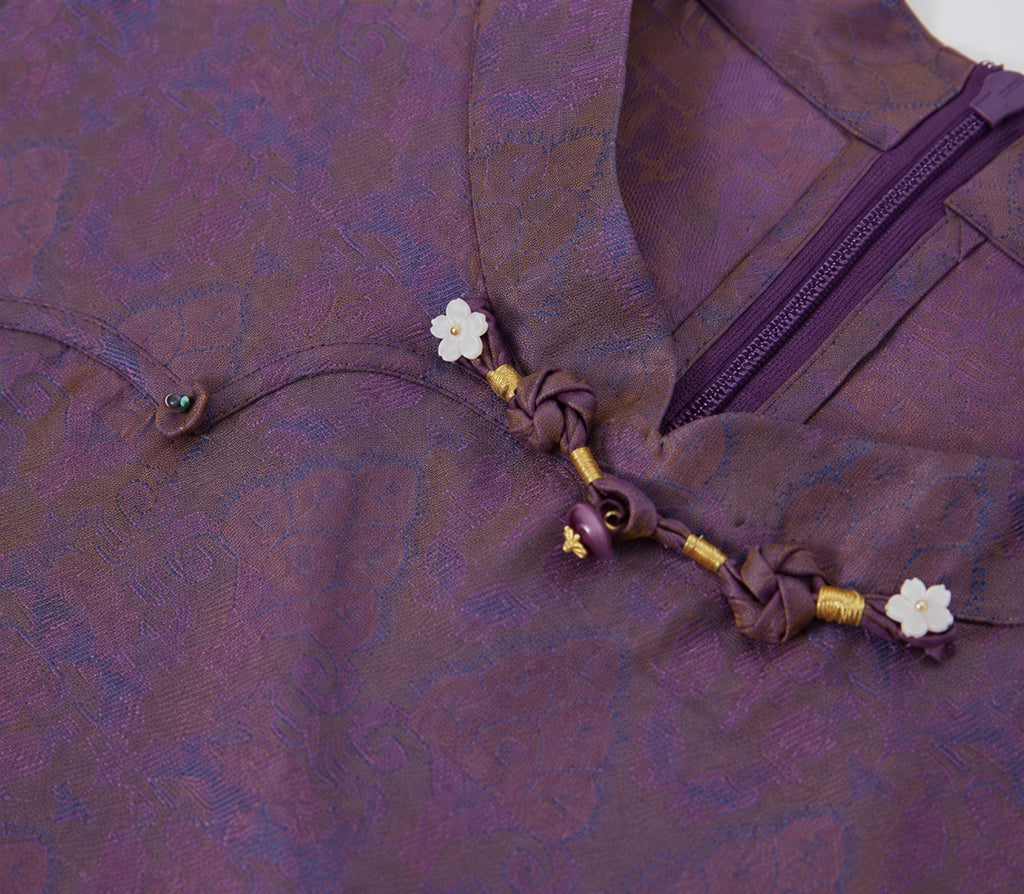 Close-up of the floral bead accents, knotted closure and concealed zipper on the silk qipao dress.