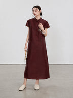 Full-length view of the oxblood-red Xiangyunsha qipao with lotus-inspired embroidery