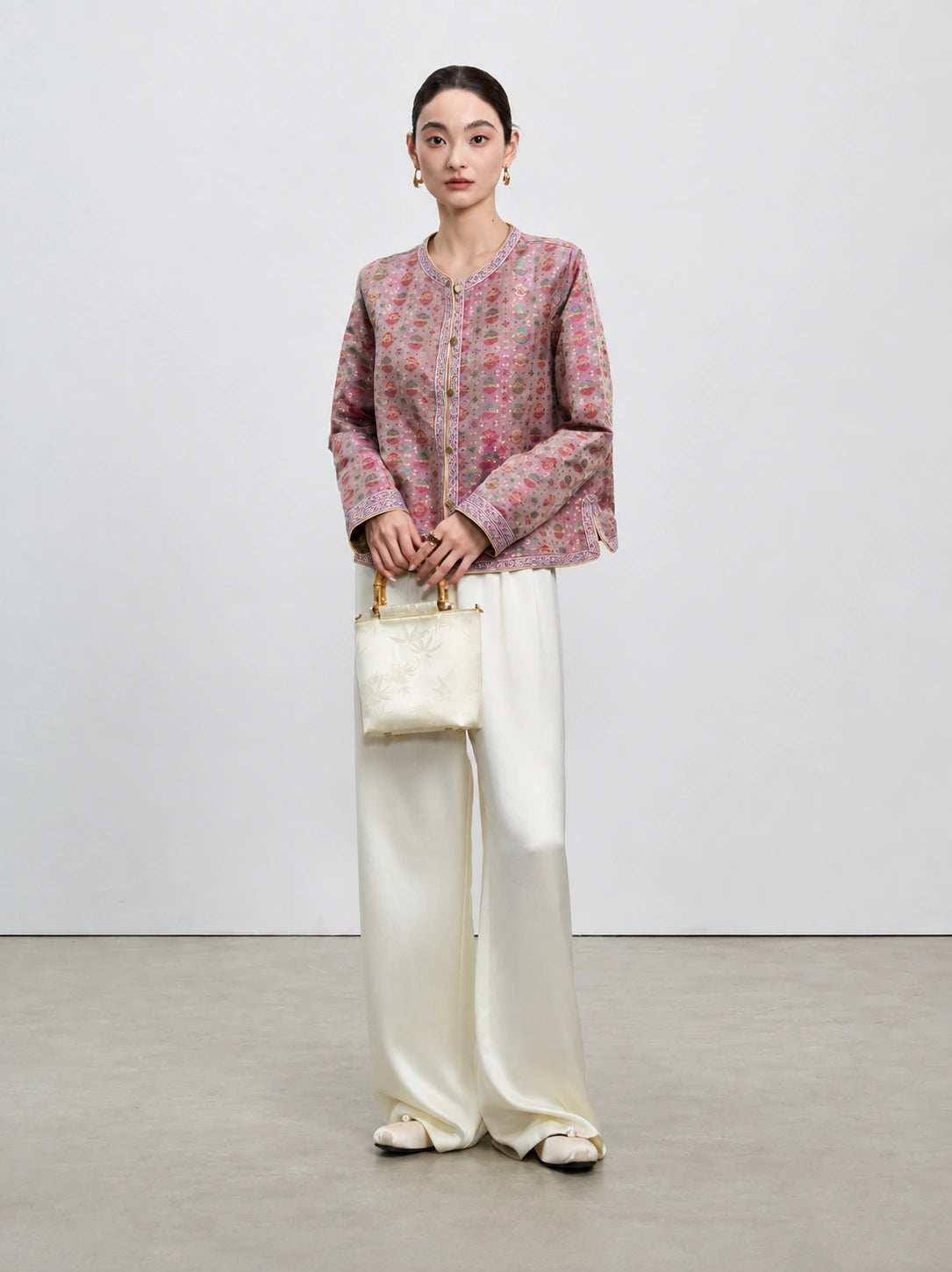 Full-length front styling of the dusty mauve reversible Shu brocade silk jacket.