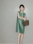 Woman wearing the jade-green side of the reversible sleeveless Song brocade silk dress.