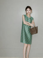 Woman wearing the jade-green side of the reversible sleeveless Song brocade silk dress.