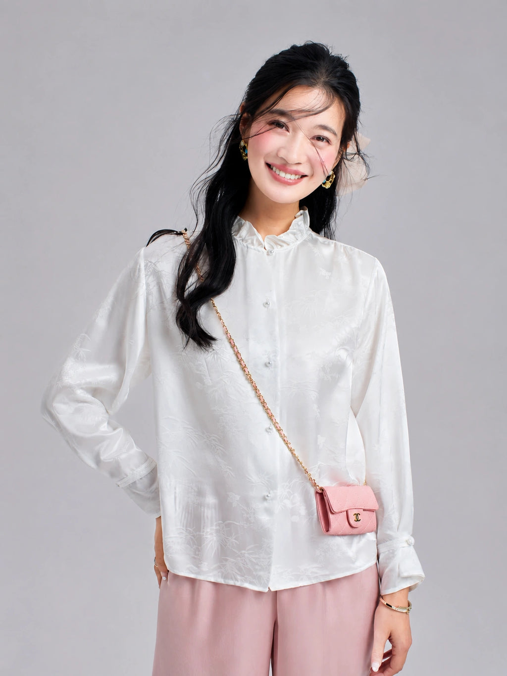Model wearing a pearl-white jacquard silk blouse with a ruffled stand collar and long sleeves.