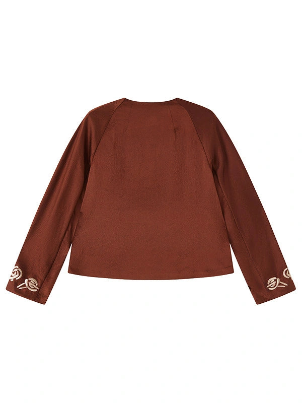 Back view of a rust-brown mulberry silk jacket with ivory embroidery at the cuffs.
