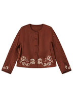 Front view of a rust-brown gambiered silk jacket with ivory embroidery and covered buttons.