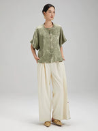 Angled view of the Sage Green Jacquard Mandarin Collar Blouse highlighting its flowing silhouette and jacquard texture.