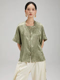 Front view of the Sage Green Jacquard Mandarin Collar Blouse by Gambiered Silk featuring a relaxed fit and decorative frog buttons.