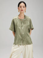 Front view of the Sage Green Jacquard Mandarin Collar Blouse by Gambiered Silk featuring a relaxed fit and decorative frog buttons.