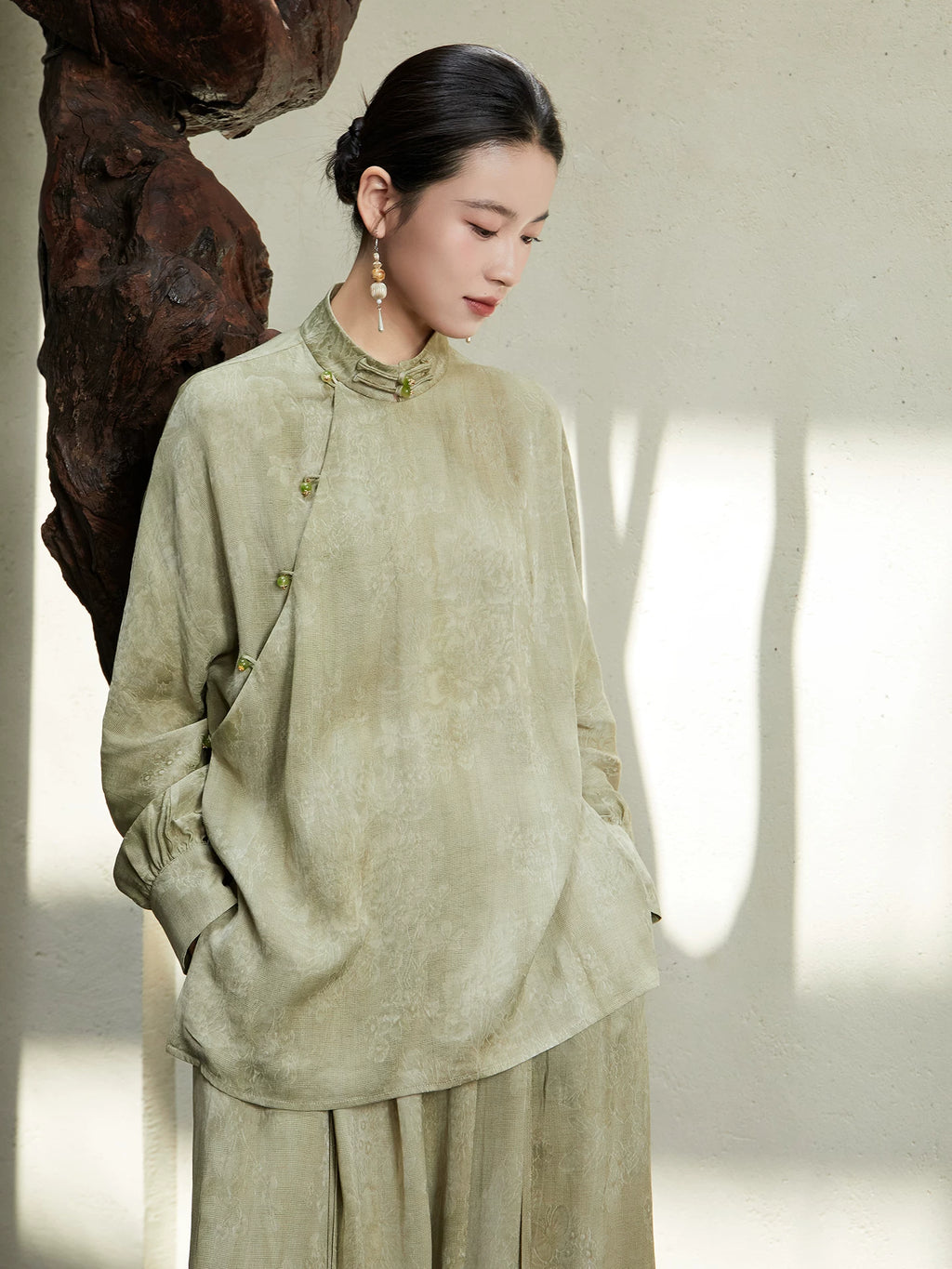 Close-up of the Sage Green Mandarin Collar Lyocell Blend Blouse highlighting the jacquard texture, mandarin collar and handcrafted frog buttons.