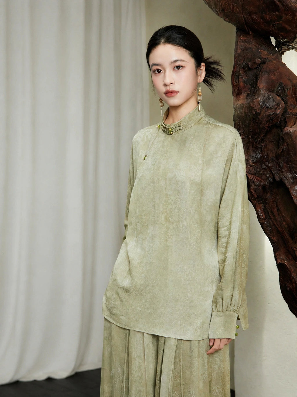 Front view of the Sage Green Mandarin Collar Lyocell Blend Blouse by Gambiered Silk featuring a relaxed fit and traditional frog-button closure.