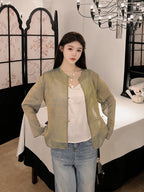 Model wearing a relaxed sage green mulberry silk jacket with a patterned finish