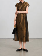 Styled view of the silk-blend qipao showing its stand collar, butterfly motifs and fine shimmer