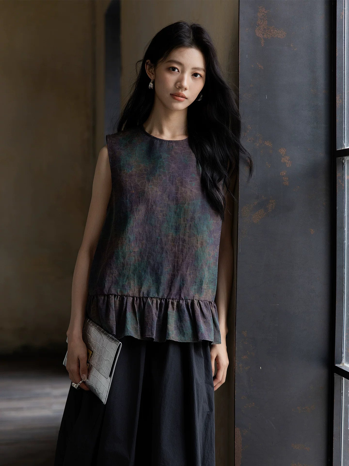 Women's sleeveless Gambiered Silk peplum blouse styled with a relaxed skirt for everyday elegance.