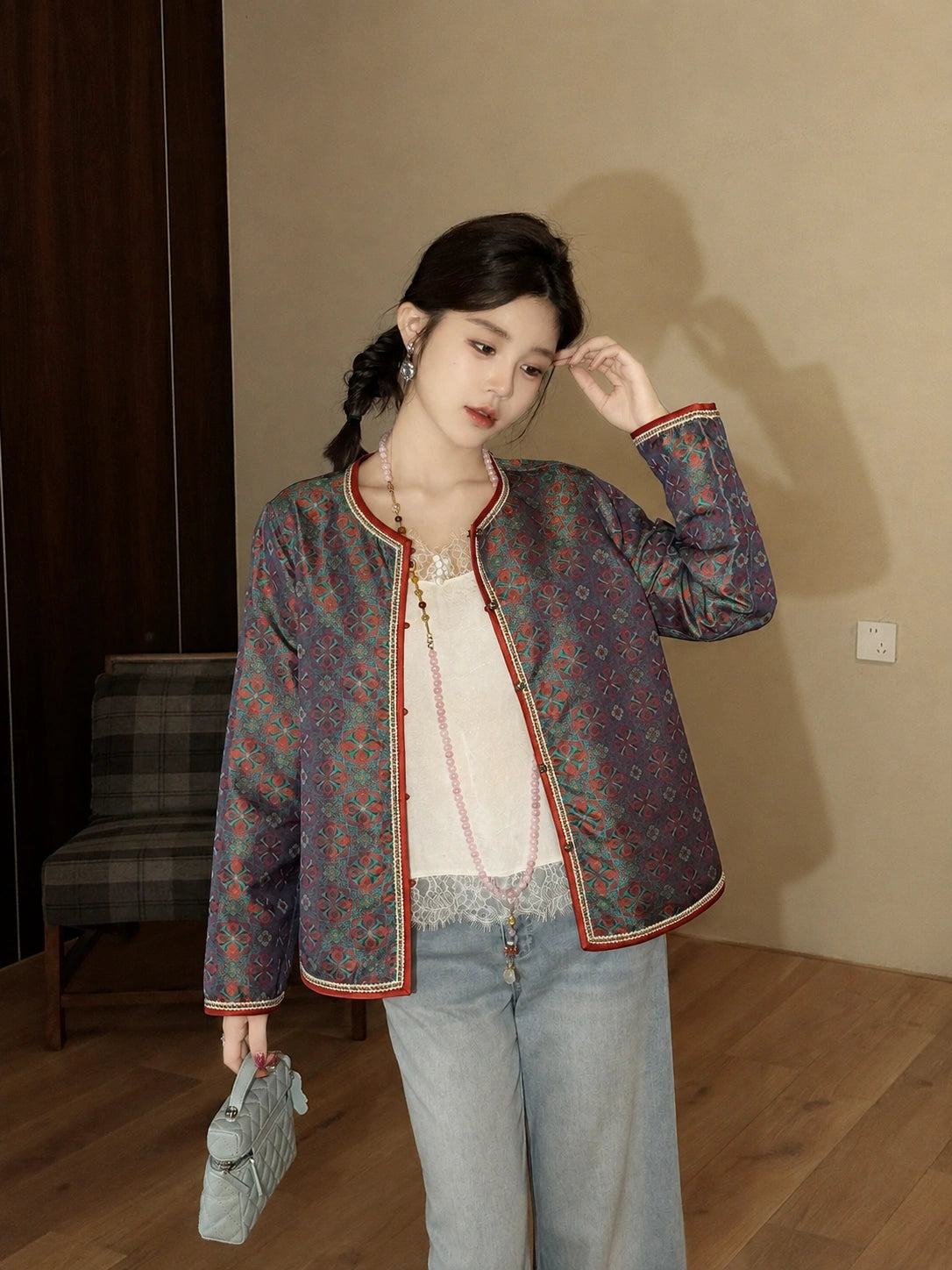 Model wearing a fitted teal silk autumn jacket with traditional Chinese-inspired detailing