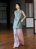 Full-length styled view of the teal jacquard longline vest worn with flowing pink trousers