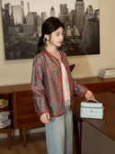 Side profile of a model wearing a patterned teal mulberry silk autumn jacket