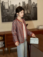 Side profile of a model wearing a patterned teal mulberry silk autumn jacket