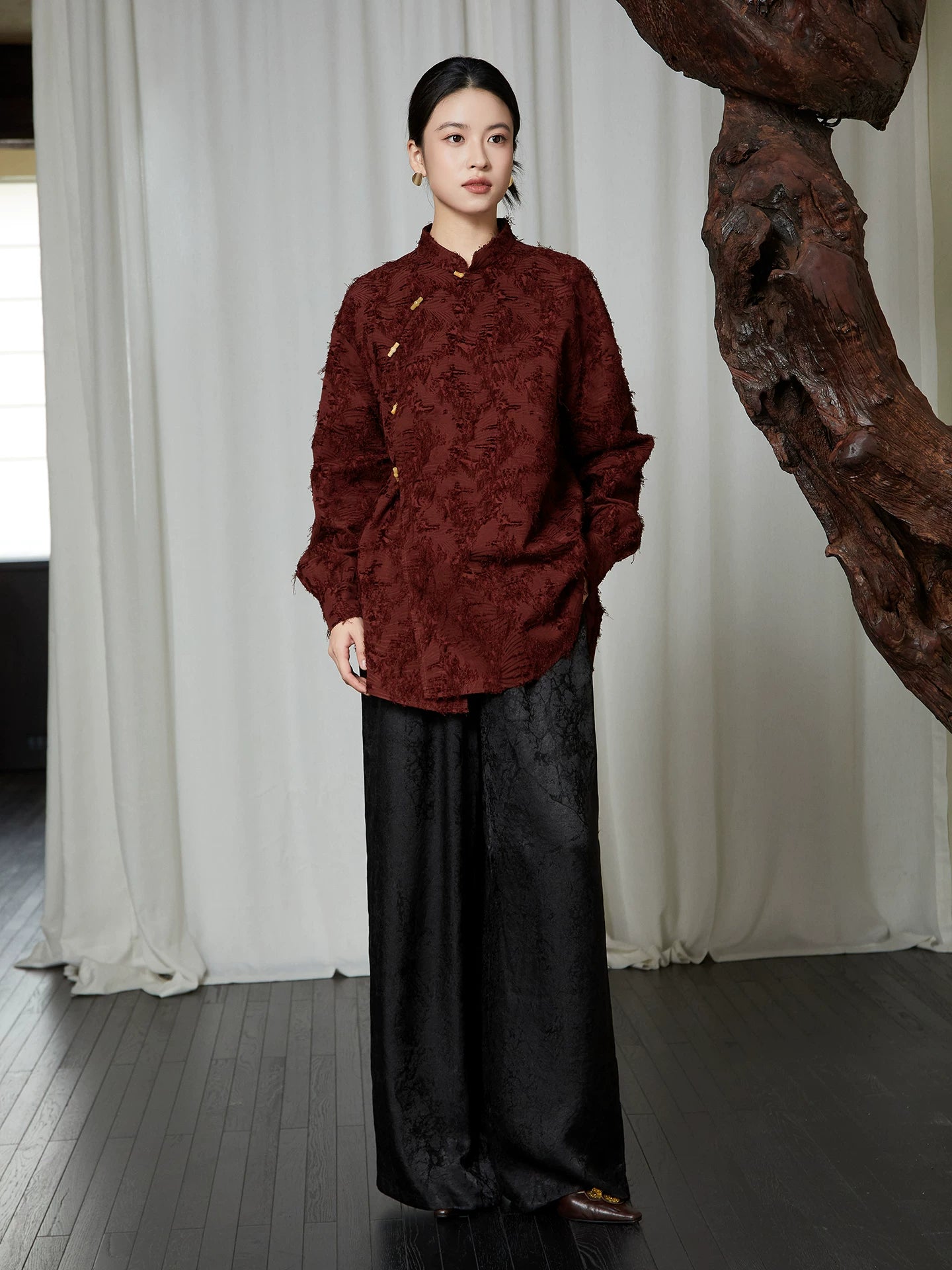 Full-length styling of the burgundy textured Mandarin Collar Cotton Blend Blouse paired with wide-leg black trousers.