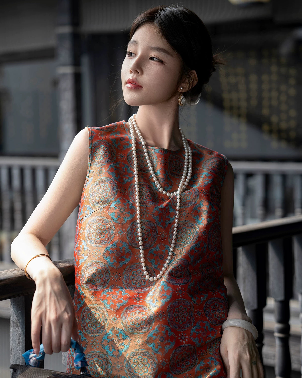 Close model view showing the turquoise and antique-gold medallion pattern of the Shu brocade dress.